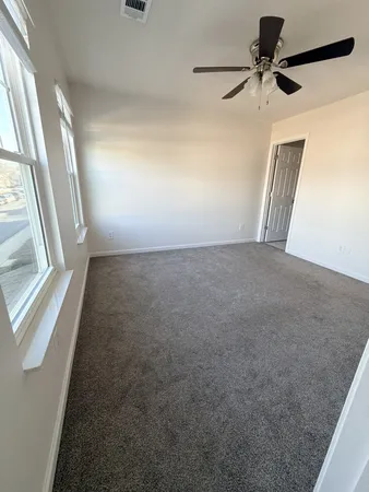 a view of an empty room and a ceiling fan