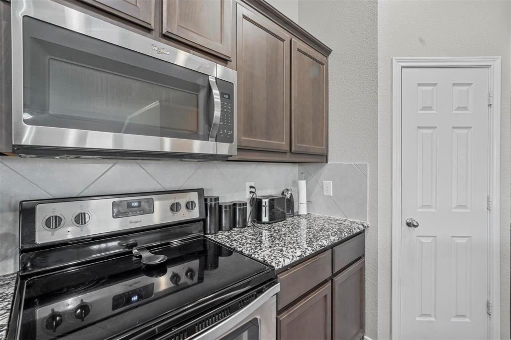 1948 Day Break Drive Lancaster, TX 75146 - Photo 11 of 25 a kitchen with a stove and white cabinets