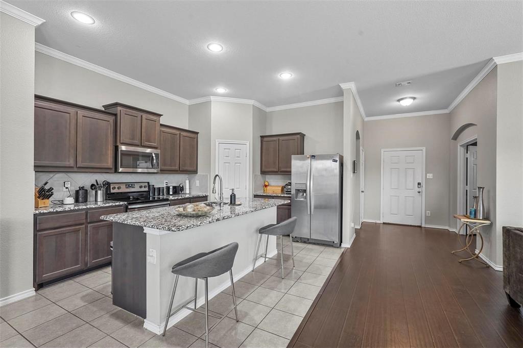 1948 Day Break Drive Lancaster, TX 75146 - Photo 3 of 25 a kitchen with stainless steel appliances granite countertop a refrigerator stove microwave and sink