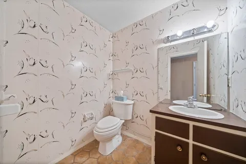 a bathroom with a toilet sink and mirror
