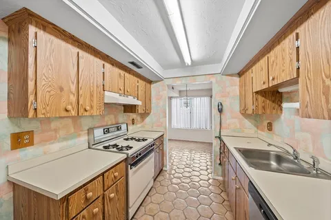 a kitchen that has a sink a stove and a microwave oven