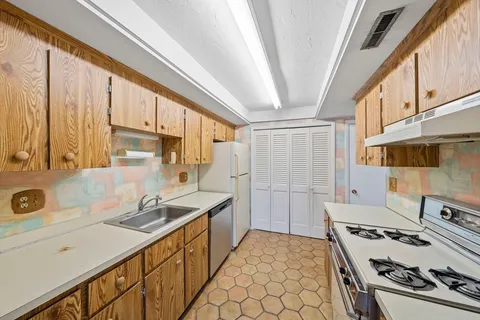 a kitchen with a sink stove top oven and cabinets