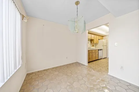 a view of a hallway with a chandelier fan and windows