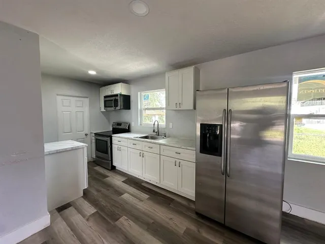a kitchen with a refrigerator and a sink