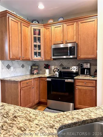 a kitchen with stainless steel appliances granite countertop a stove a sink and a microwave