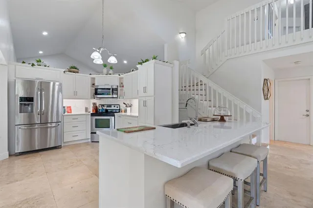 a kitchen with white cabinets and stainless steel appliances