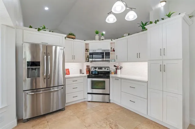 a kitchen with stainless steel appliances white cabinets and a refrigerator