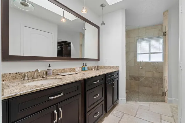a bathroom with a granite countertop sink mirror and double
