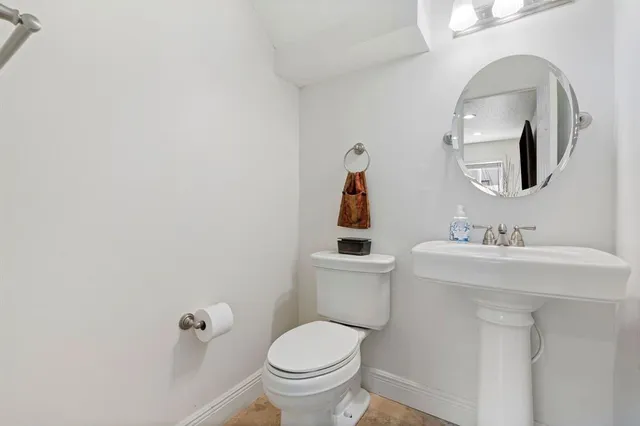 a bathroom with a toilet sink and mirror