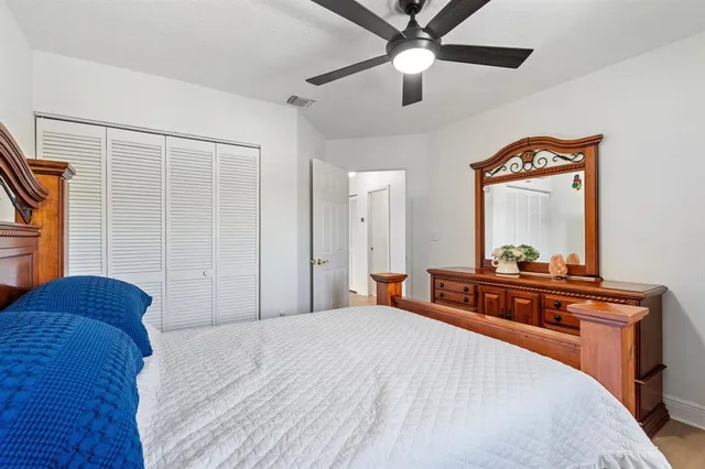 a bedroom with a bed and a mirror on dresser