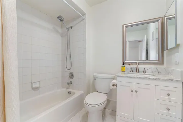 a bathroom with a granite countertop toilet a sink and a bathtub