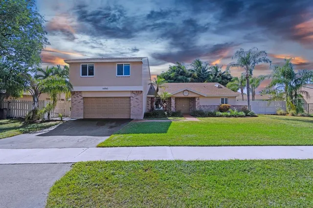 a front view of house with yard and green space