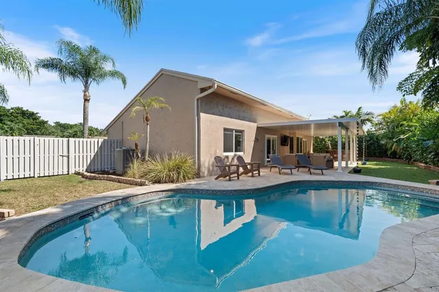 a view of a house with swimming pool and sitting area