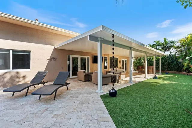 a view of a house with backyard sitting area and garden