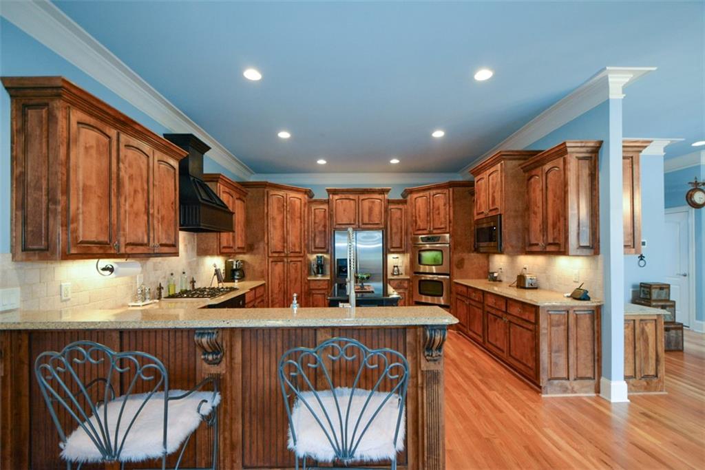 3435 Hidden Shoals Road Northeast Buford, GA 30519 - Photo 29 of 108 a kitchen with stainless steel appliances granite countertop a stove a sink and a refrigerator
