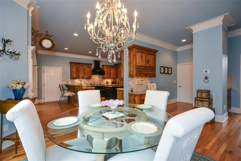 3435 Hidden Shoals Road Northeast Buford, GA 30519 - Photo 35 of 108 a dining room with furniture a chandelier and wooden floor