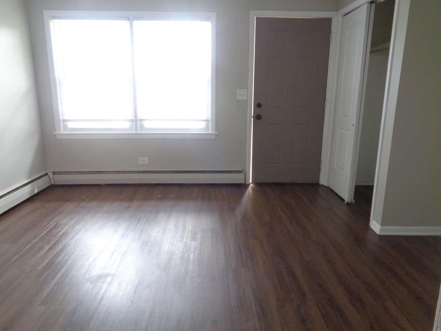 1340 North Main Street, Unit D7 Wheaton, IL 60187 - Photo 3 of 7 an empty room with wooden floor and windows