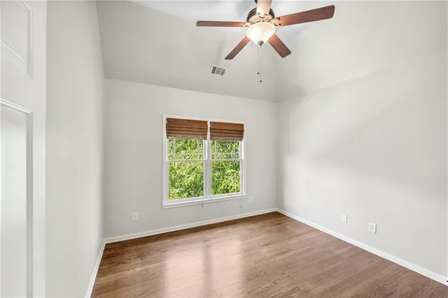 an empty room with windows and fan