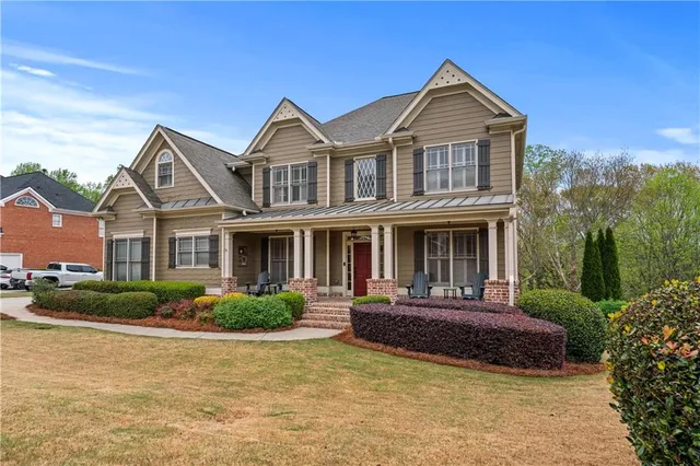 a front view of a house with a yard and lake view