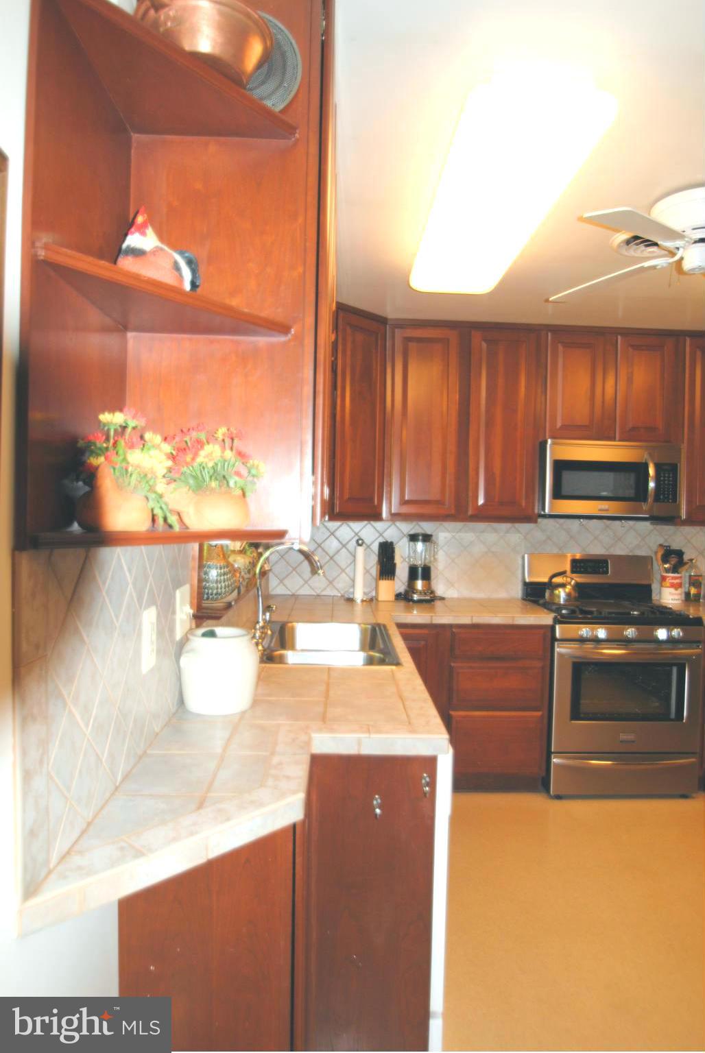 7921 Bainbridge Road Alexandria, VA 22308 - Photo 11 of 30 a kitchen with a sink a stove and wooden cabinets