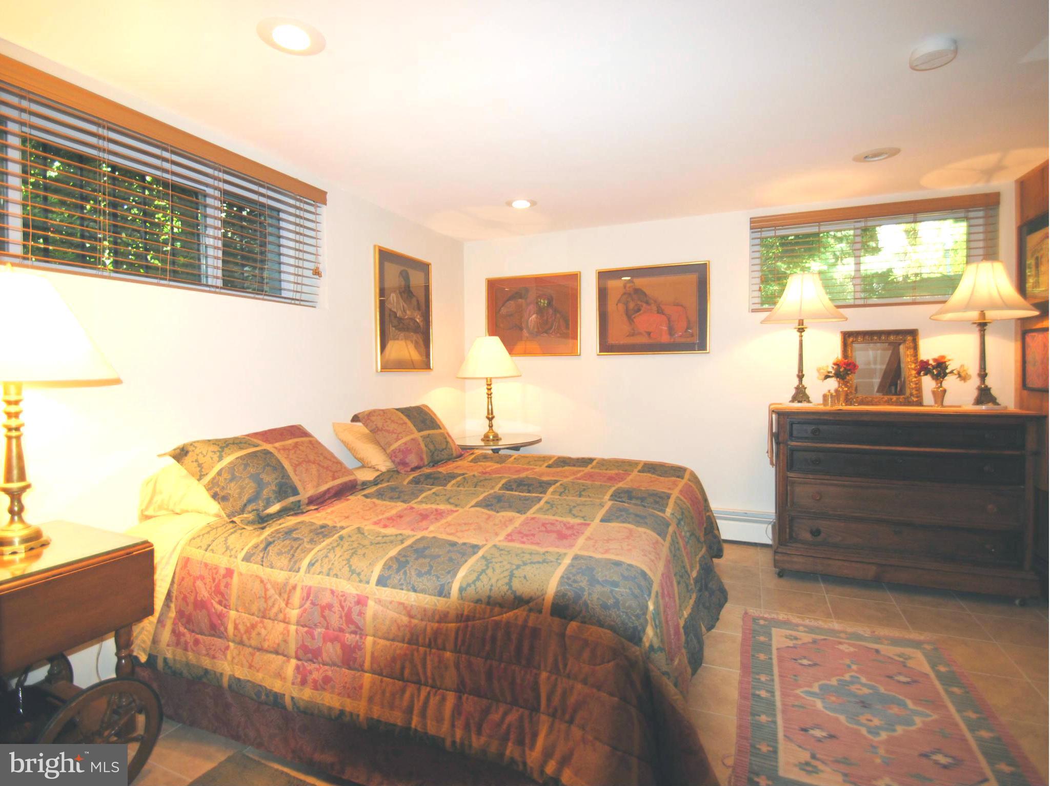7921 Bainbridge Road Alexandria, VA 22308 - Photo 18 of 30 a bedroom with a bed and a dresser next to a window