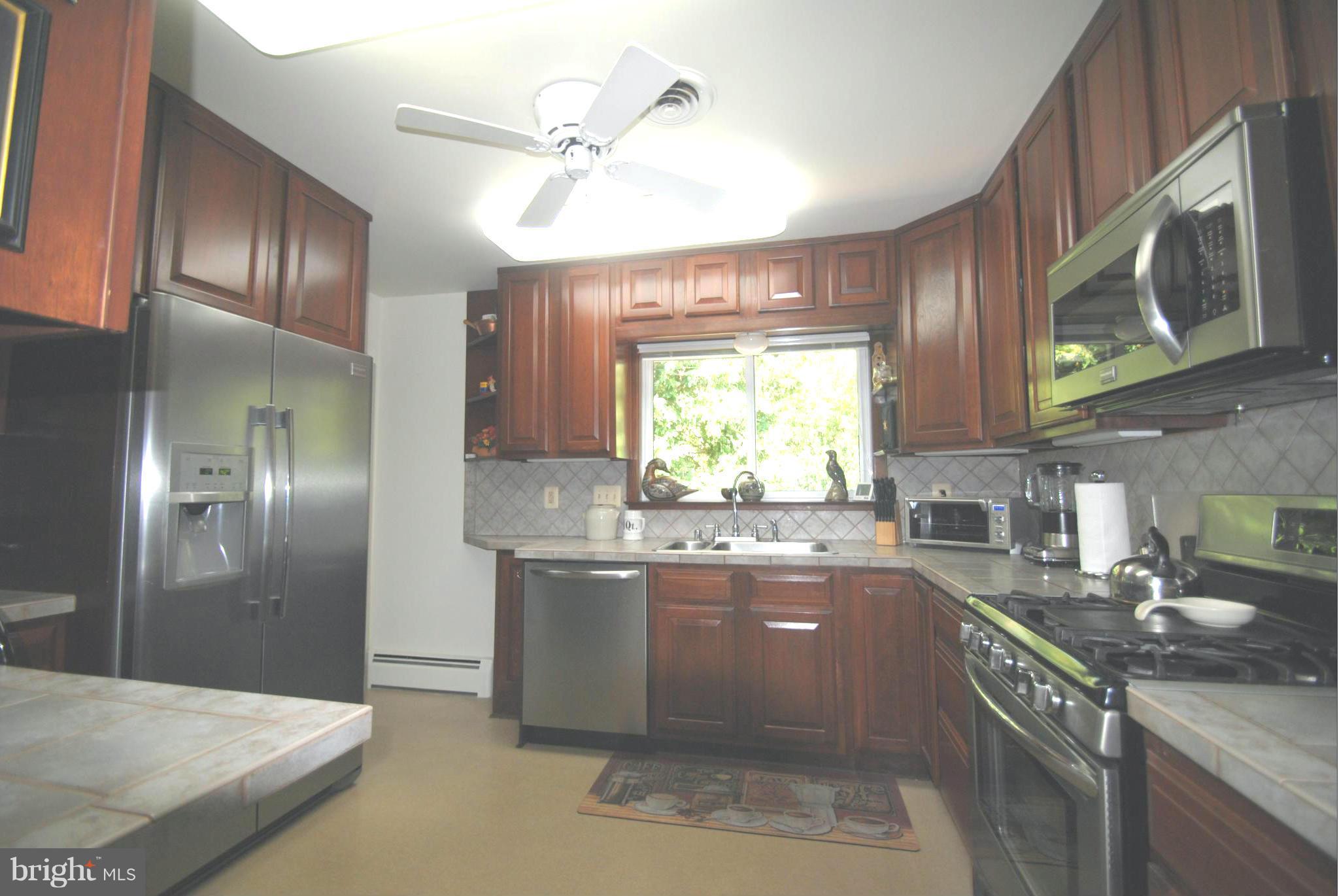 7921 Bainbridge Road Alexandria, VA 22308 - Photo 8 of 30 a kitchen with granite countertop a sink stainless steel appliances a counter space and cabinets