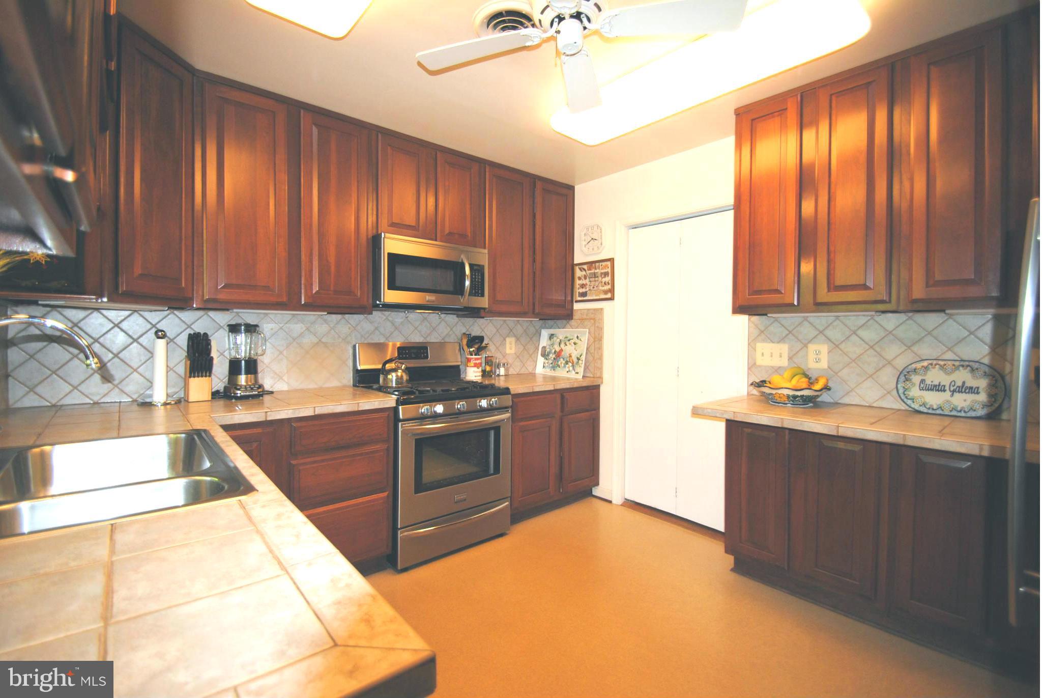 7921 Bainbridge Road Alexandria, VA 22308 - Photo 9 of 30 a kitchen with stainless steel appliances granite countertop a stove a sink and a refrigerator