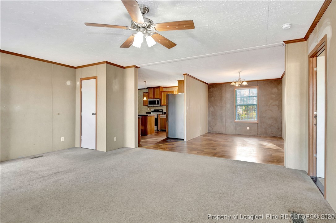 193 Fork Pine Road Lumberton, NC 28358 - Photo 8 of 40 a view of a livingroom with a chandelier fan and kitchen view