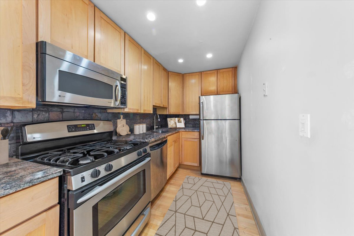 3900 North Pine Grove Avenue, Unit 910 Chicago, IL 60613 - Photo 5 of 18 a kitchen with stove cabinets and a refrigerator