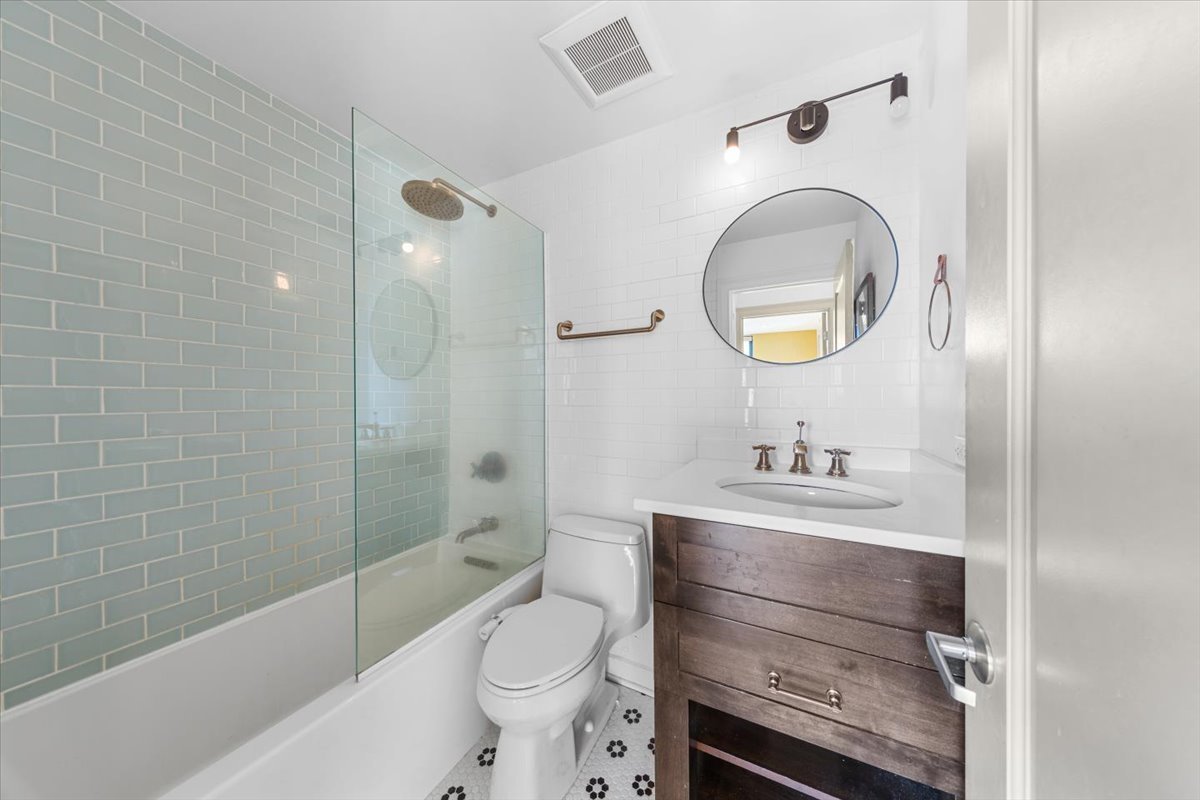 3900 North Pine Grove Avenue, Unit 910 Chicago, IL 60613 - Photo 7 of 18 a bathroom with a toilet a sink and bathtub