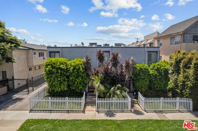 a view of a house with a yard and potted plants