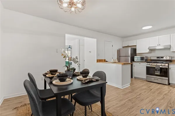 a kitchen with a dining table chairs and refrigerator
