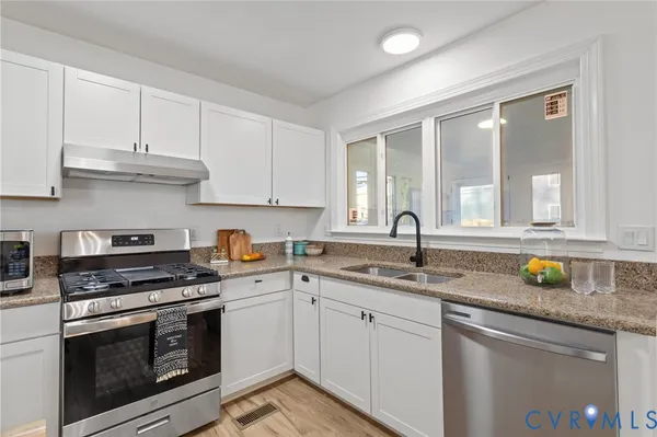 a kitchen with granite countertop a stove and a sink