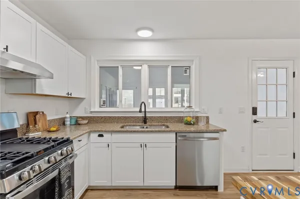 a kitchen with granite countertop a sink and a stove