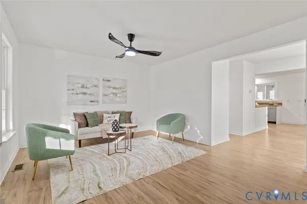 a living room with furniture and a wooden floor