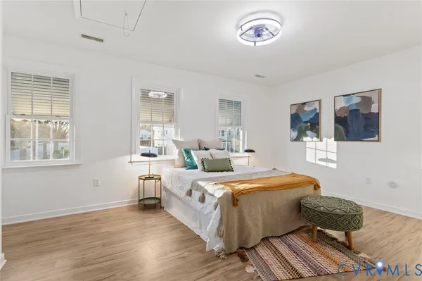 a bedroom with a bed and wooden floor