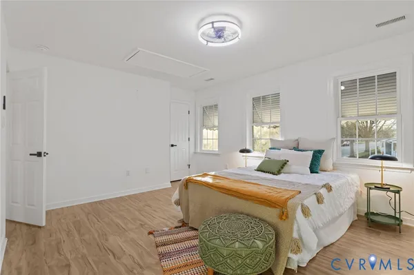 a bedroom with a bed wooden floor and window