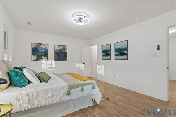 an empty room with chandelier fan and windows