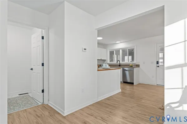 a open kitchen with white cabinets and wooden floor
