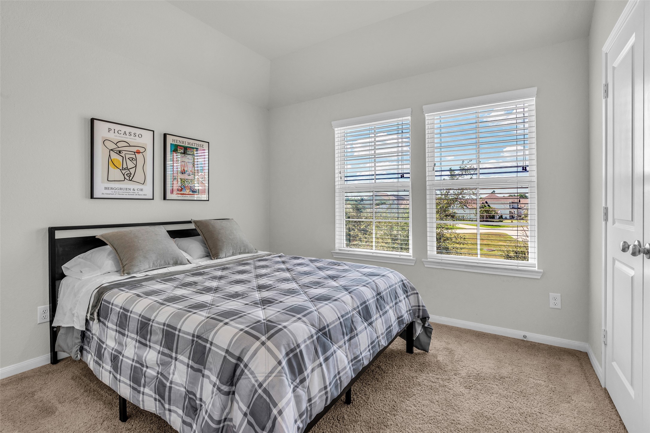 2344 Hagerman Road Conroe, TX 77384 - Photo 17 of 27 Cozy bedroom featuring plush carpeting, ample natural light from large windows, and tasteful wall art.