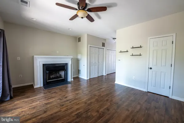 an empty room with wooden floor a fireplace
