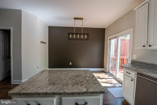 a kitchen with granite countertop a stove a sink and a refrigerator