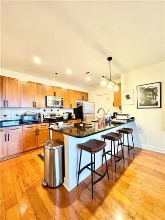 a kitchen with stainless steel appliances a stove a sink and a refrigerator