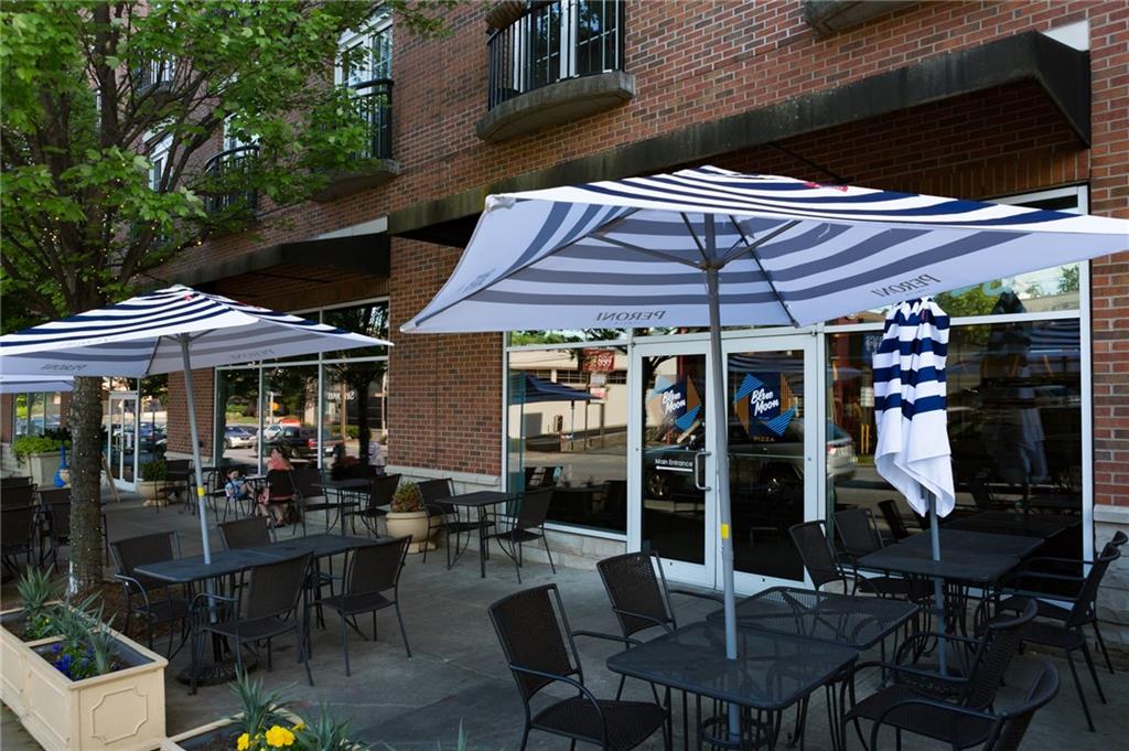 325 East Paces Ferry Road Northeast, Unit 1701 Atlanta, GA 30305 - Photo 36 of 46 a patio with a table and chairs under an umbrella
