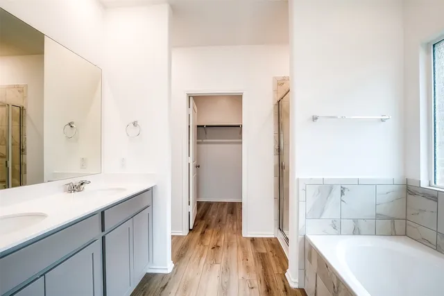 a spacious bathroom with a tub sink and mirror