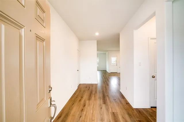 a view of a hallway with wooden floor and staircase