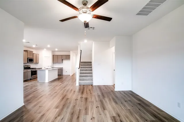 a view of a living room hardwood floor and a ceiling fan