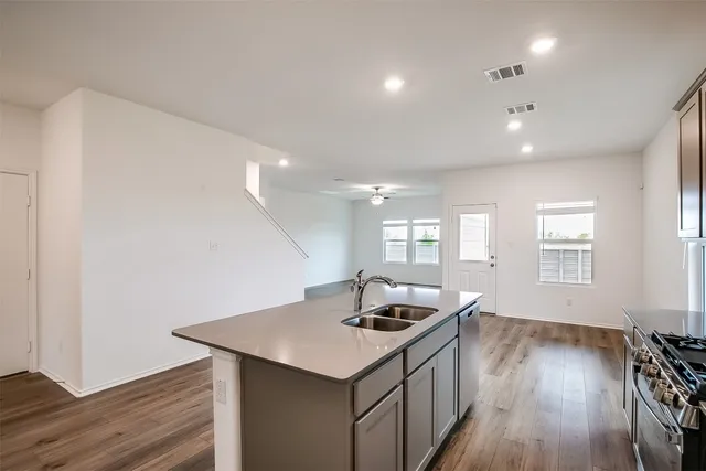 a kitchen with a sink and wooden floor