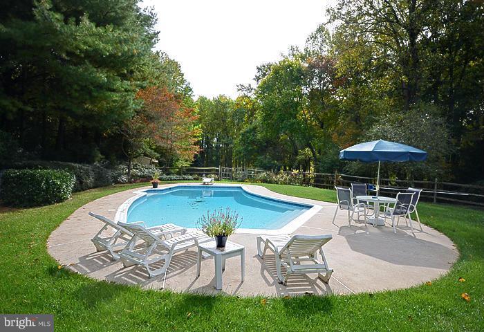 2415 Engle Road Fallston, MD 21047 - Photo 27 of 29 a view of a swimming pool with lawn chairs under an umbrella