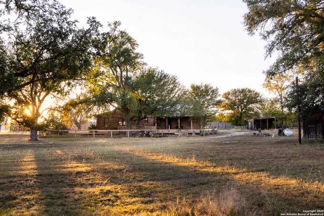 a view of a dry yard with wooden fence
